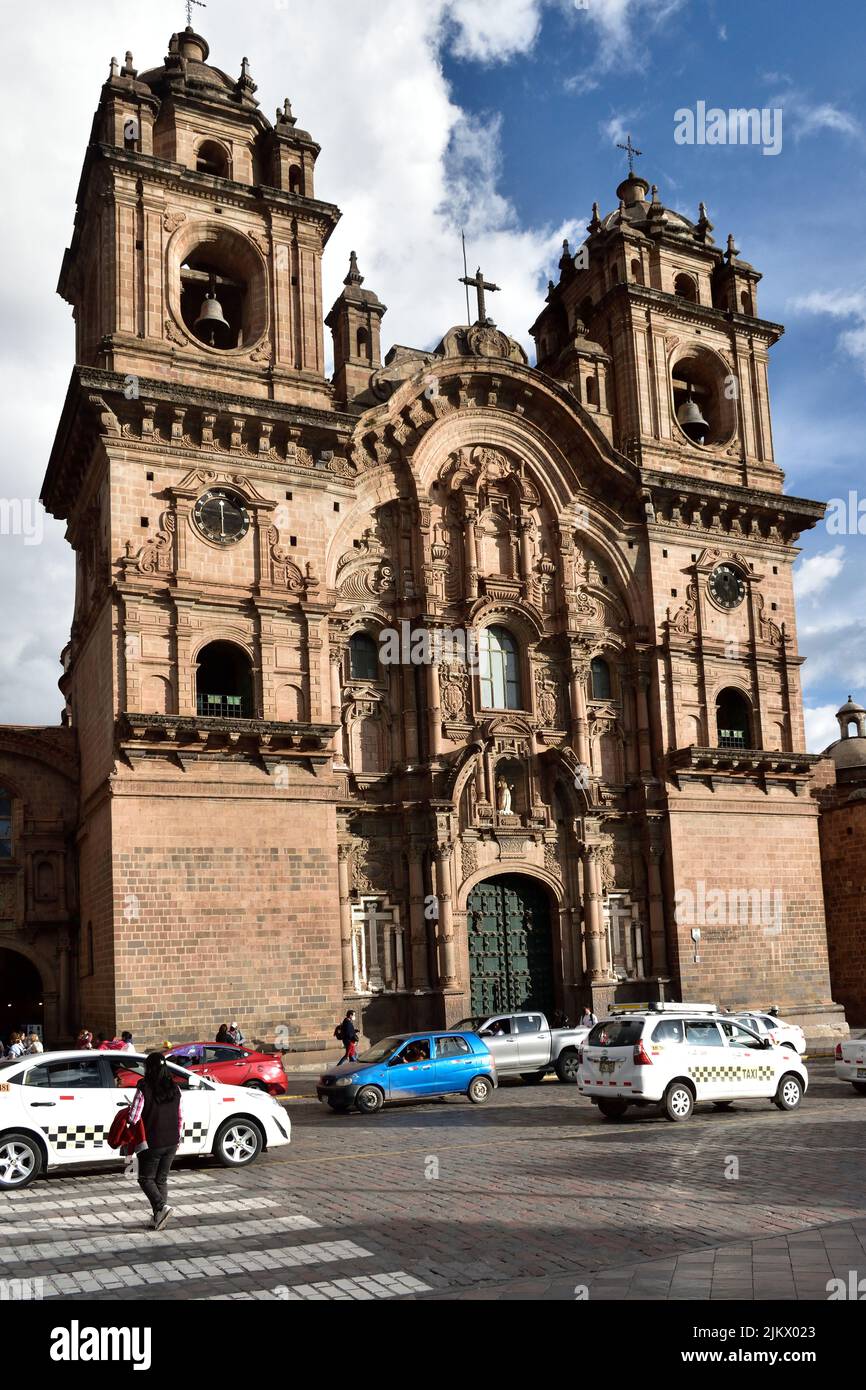 Eine vertikale Aufnahme des geschäftigen Verkehrs gegen die Kirche der Gesellschaft Jesu in Cusco, Peru Stockfoto
