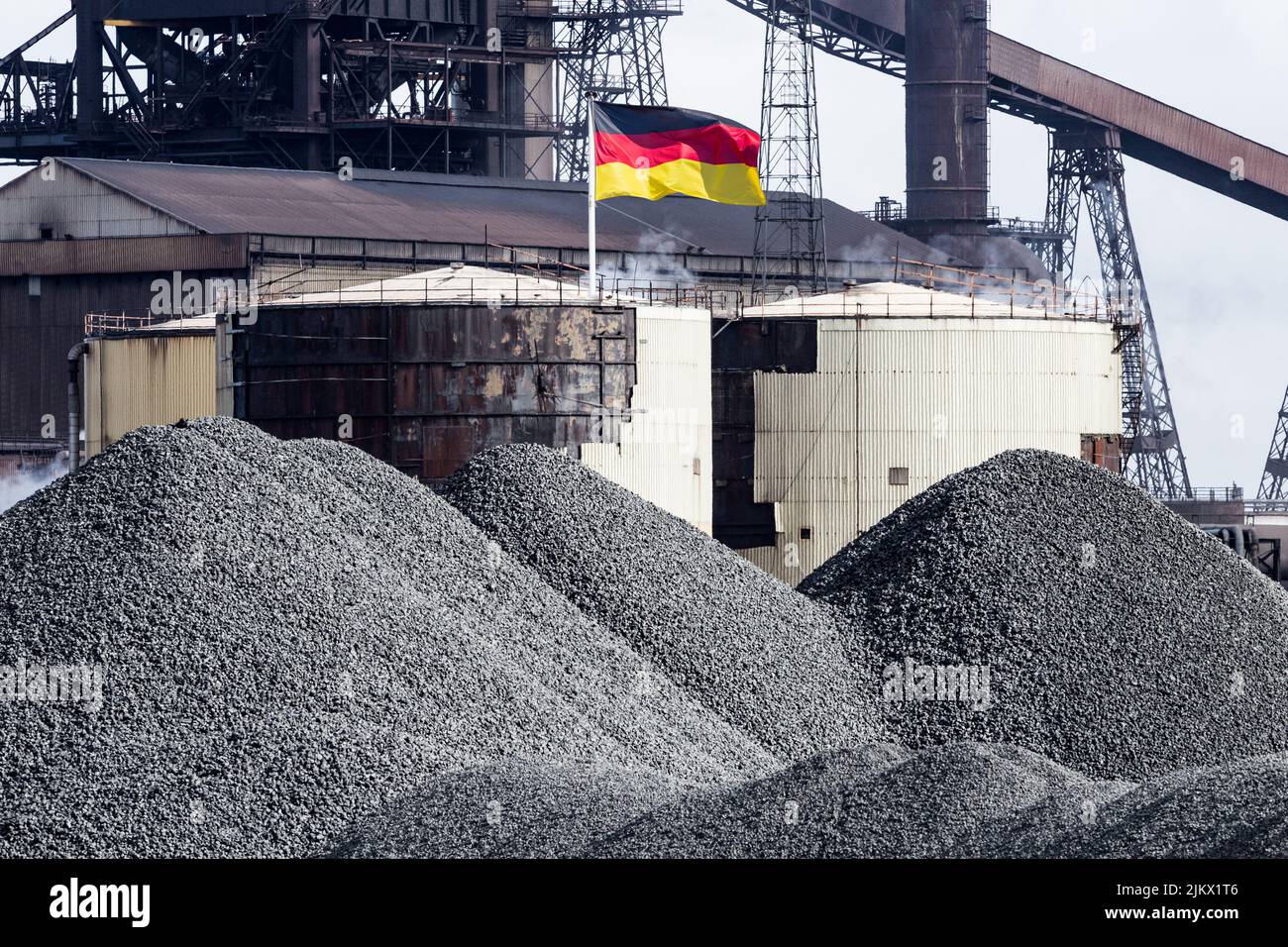 Flagge Deutschlands mit Kohle/Koks im Vordergrund. Fossile Brennstoffe, Kohle, Energie, Gas, Krise, Preise, Russland, russisches Gas... Konzept Stockfoto