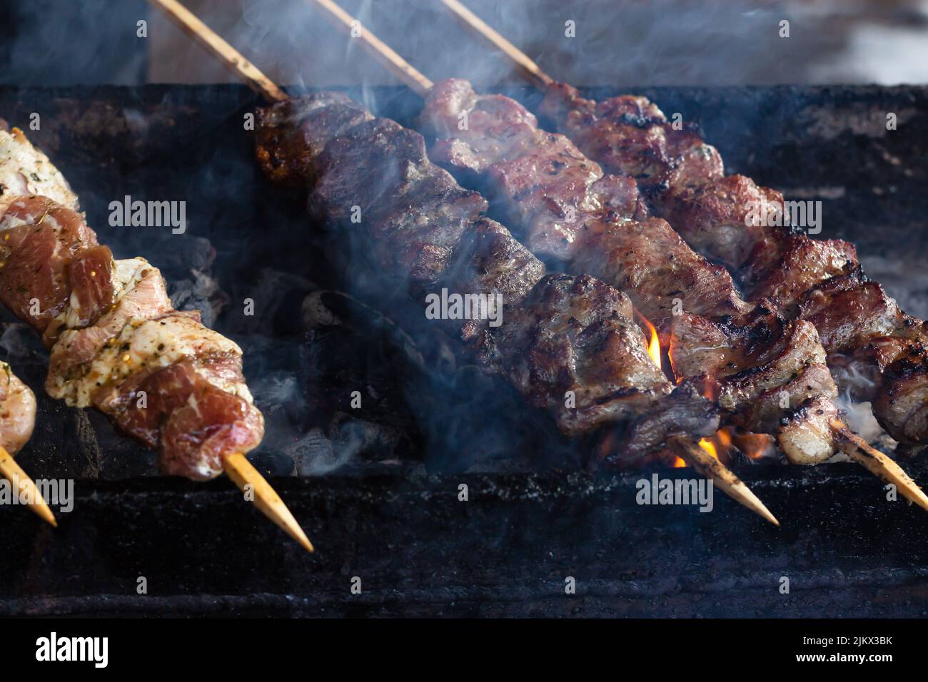 Marinierter Schaschlik, der auf einem Barbecue-Grill über Holzkohle zubereitet wird. Schaschlik oder Schisch Kebab beliebt in Russland. Braten von Rindfleisch-Kebabs auf dem BBQ Grill. Appetitlich, Stockfoto