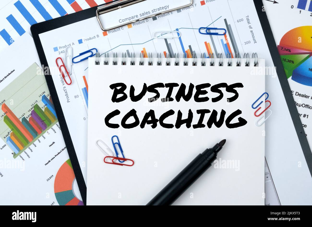 Business und Finanzen. Auf der Tabelle sind Berichte, Diagramme, ein Notizbuch mit der Aufschrift - BUSINESS COACHING Stockfoto