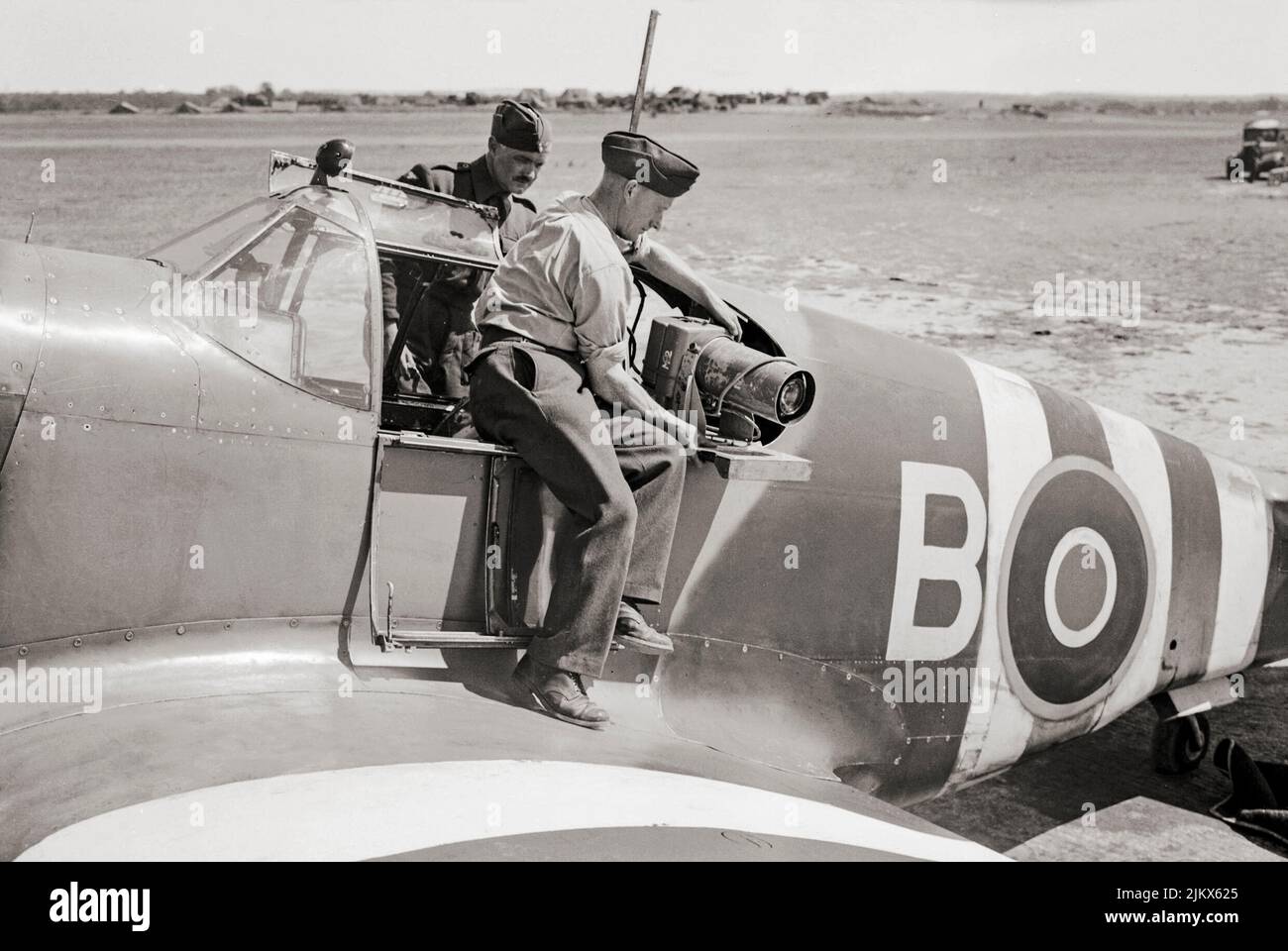 Instrumentenmonteure installieren eine Luftkamera (Typ F.24 (14-Zoll-Objektiv) in der schrägen Position des Hafens in einem North American Aviation P-51 Mustang Mark IA von No. 35 (Reconnaissance) Wing in Gatwick, Sussex, England. Stockfoto