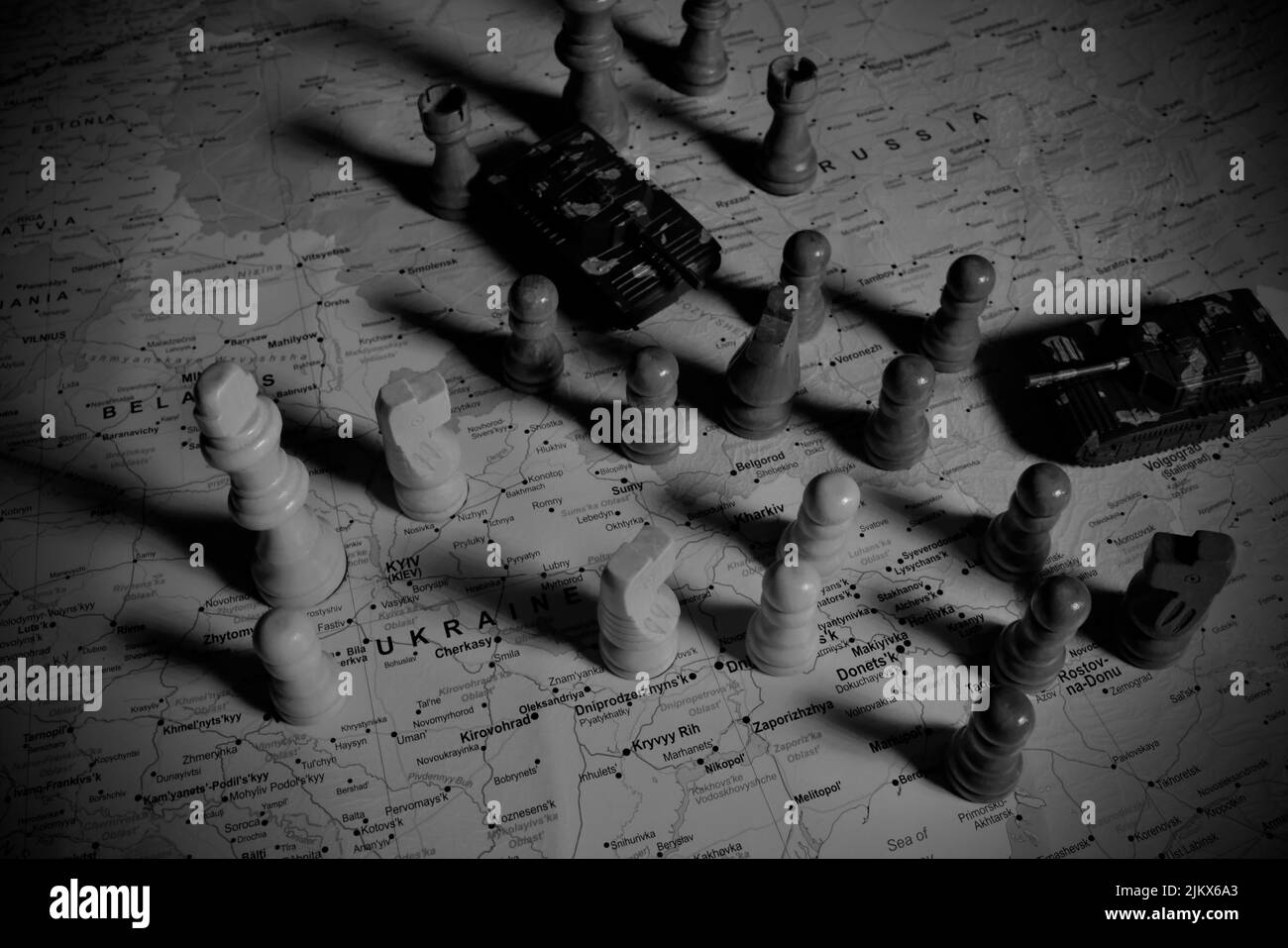 Eine Draufsicht auf Schachfiguren mit Miniaturpanzern auf einer Karte von Russland und der Ukraine - Kriegskonzept Stockfoto