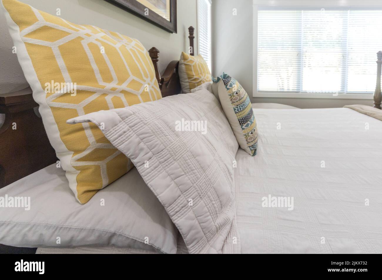 Dekorative Kissen auf einem großen Bett in einem hellen und luftigen Hauptschlafzimmer Stockfoto