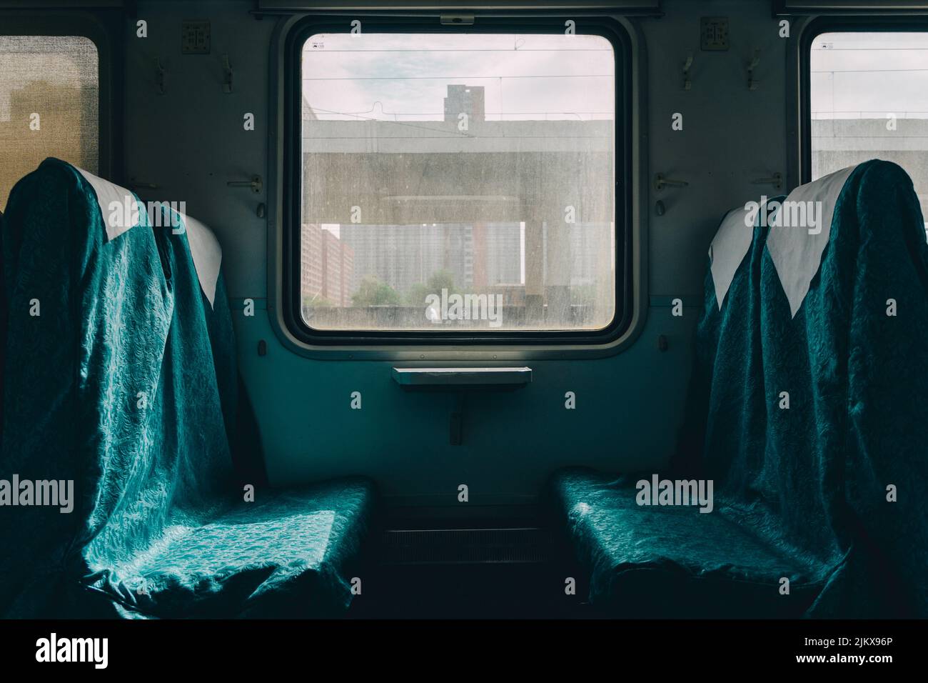 Blick auf die sich gegenüberliegenden Bahnstühle zwischen einem Fenster Stockfoto