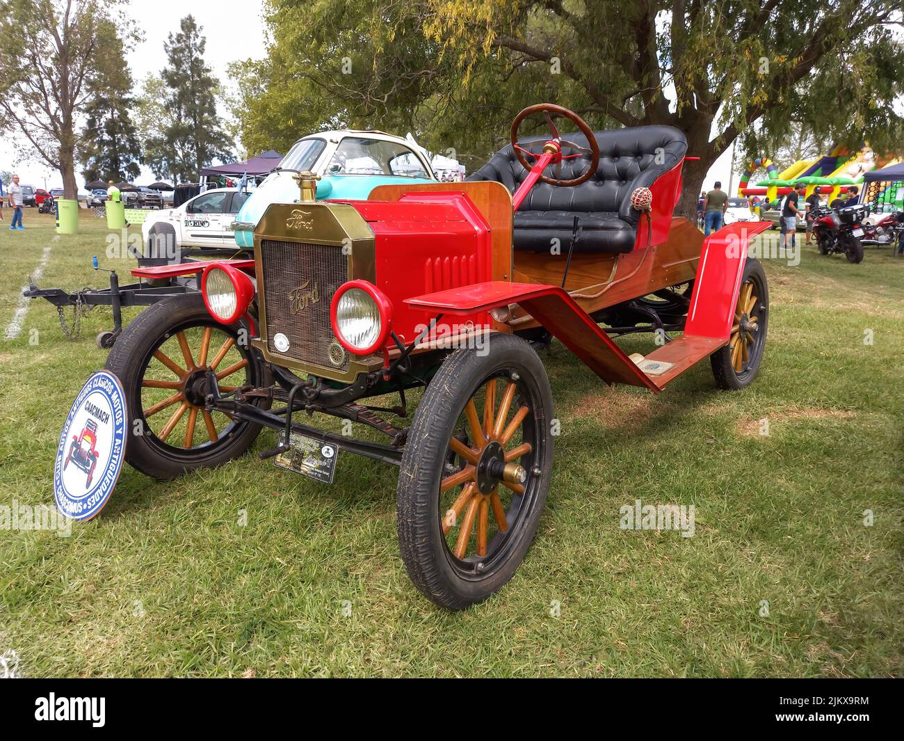 Chascomus, Argentinien - 9. Apr 2022: Alter roter Ford Model T Roadster Tudor um 1920. Seitenansicht. Natur grünes Gras und Bäume Hintergrund. Oldtimer-sh Stockfoto