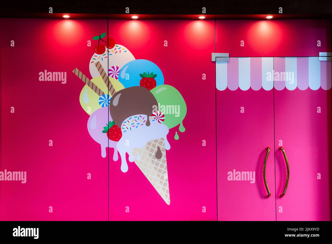 Eine schöne Aufnahme einer Tür in der Nähe eines bunten Gemäldes auf Eis an einer rosa Wand Stockfoto