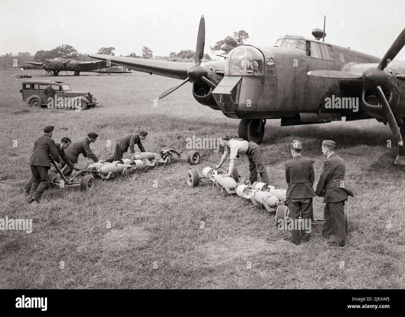 Waffenwagen mit 500 Pfund schweren GP-Bomben in Richtung der offenen Bombenbucht eines Armstrong Whitworth Whitley Mark V der Squadron RAF Nr. 58 in Linton-on-Ouse, Yorkshire, England. Der Armstrong Whitworth Whitley war ein britischer mittlerer Bomber, einer von drei zweimotorigen, Mittlere Bombertypen an der Front im Einsatz bei der Royal Air Force (RAF) bei Ausbruch des Zweiten Weltkriegs. Neben Vickers Wellington und Handley Page Hampden. 1942 wurde sie als Bomber von den größeren viermotorigen „Schweren“ wie der Avro Lancaster abgelöst. Stockfoto