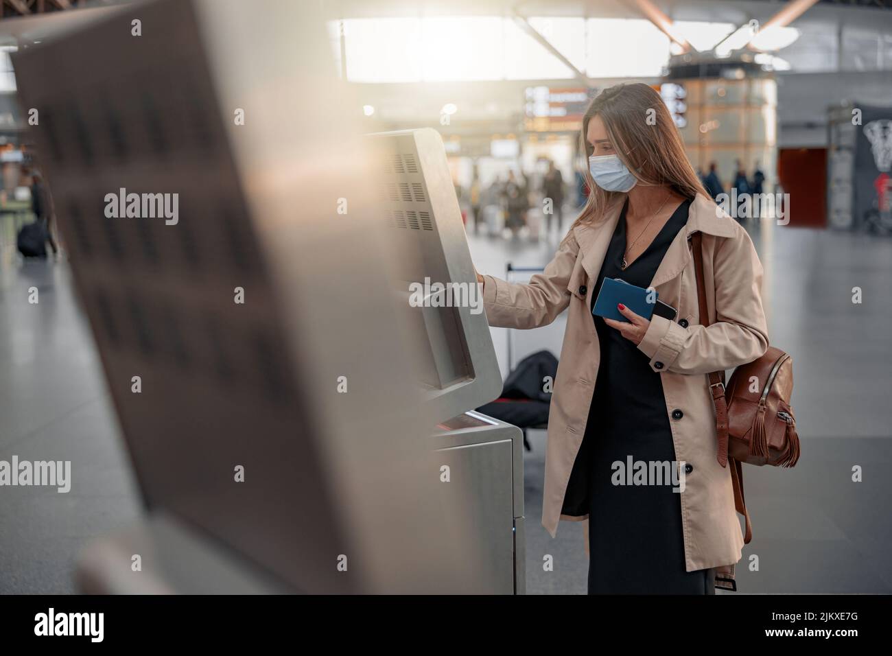 Junge Dame berührt den interaktiven Bildschirm, um online einzuchecken Stockfoto