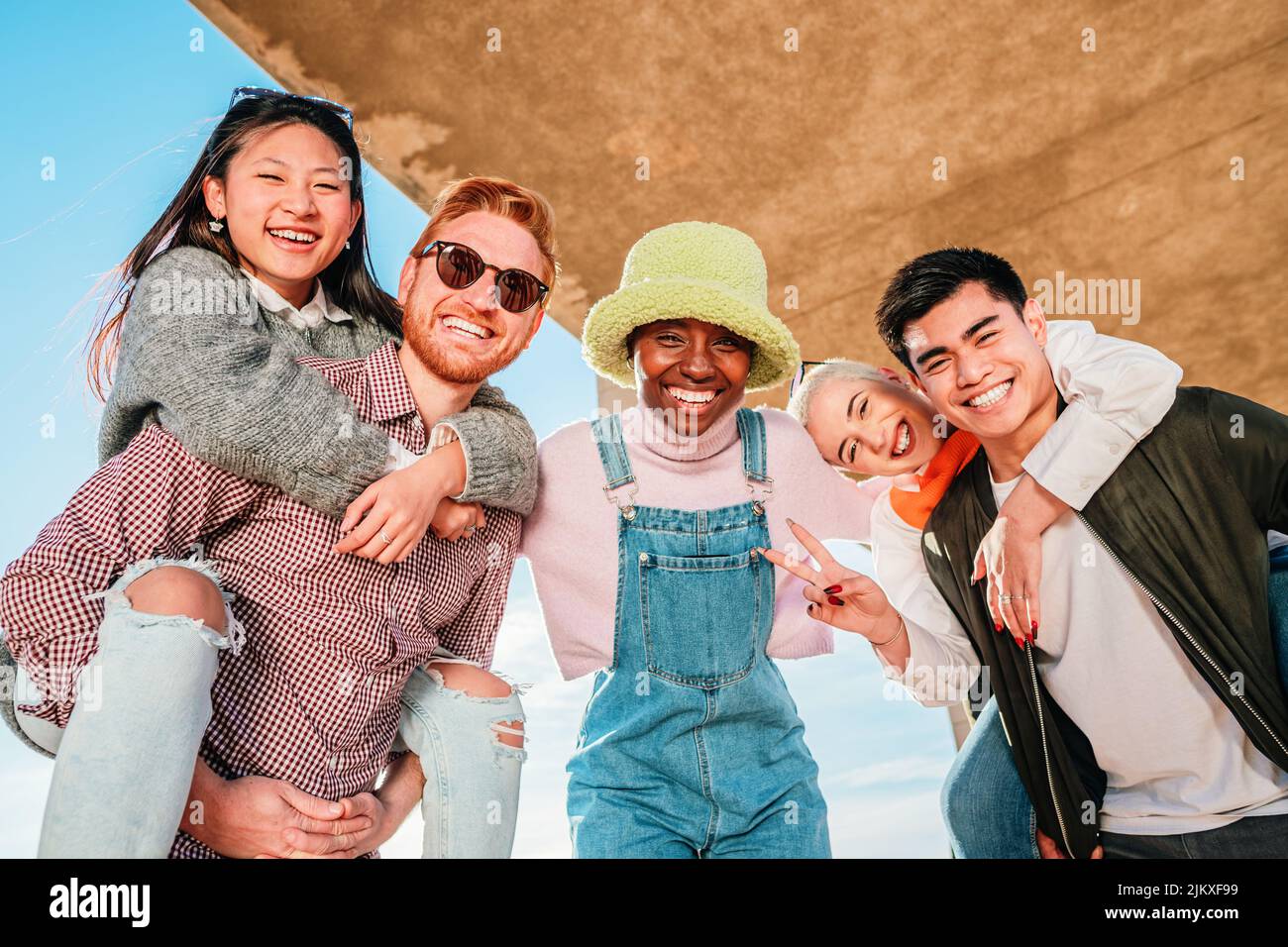 Gruppe von fünf multiethnischen Freunden, die lächeln und Spaß beim Betrachte der Kamera haben. Stockfoto