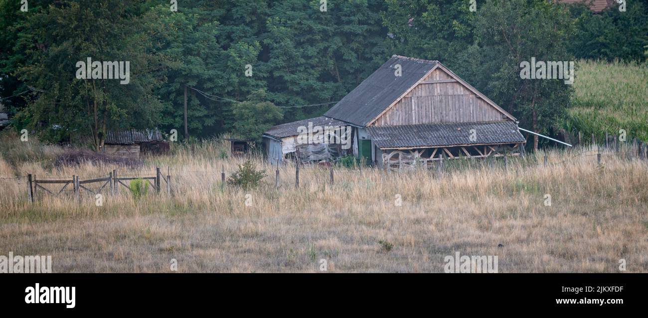 Landschaftlich schöner Blick auf ein altes Bauernhaus aus Holz im Verfall in der ländlichen Landschaft von Siebenbürgen, Rumänien Stockfoto