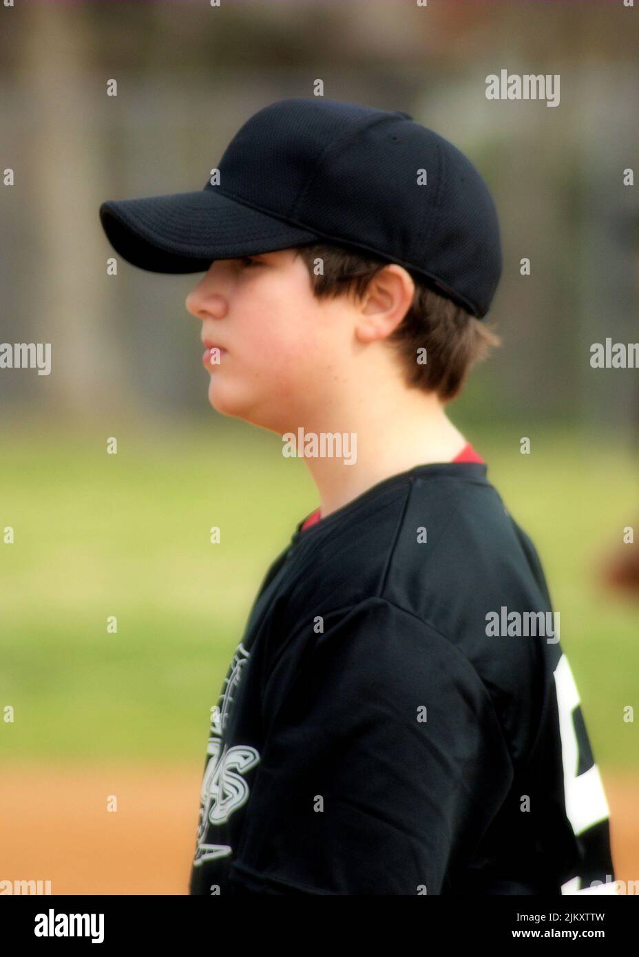 Junger, entspannter Baseballspieler, der einen ruhigen Moment im Dugout genießt. Stockfoto