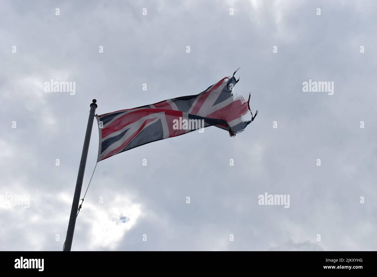 Eine zerfetzte Union-Jack-Flagge vor einem bewölkten Himmel. Stockfoto