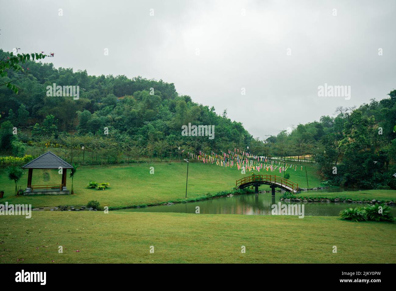 Blick auf eine schöne Grünanlage mit Pavillons und Hügeln und einem Teich in der Mitte Stockfoto