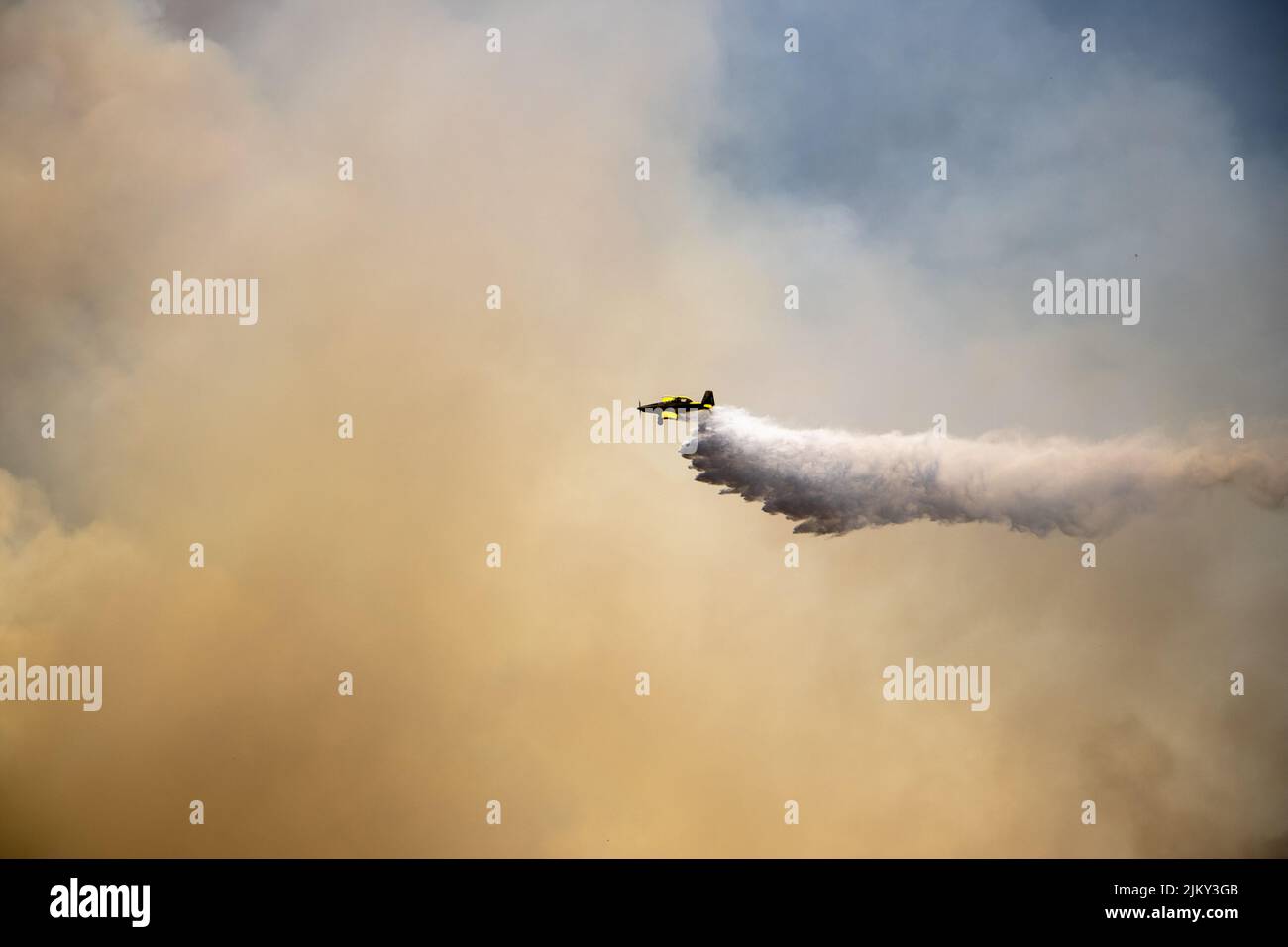 Ein Blick auf ein Feuerwehrflugzeug, das eine Ladung Wasser vom Himmel fallen lässt Stockfoto