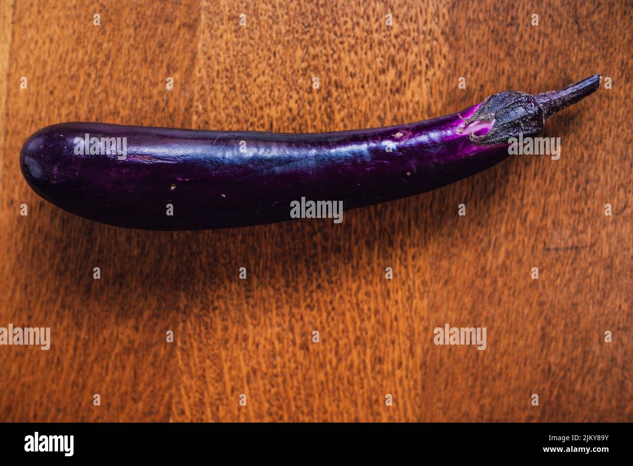 Lange, dünne lila chinesische Aubergine auf Holztisch Stockfoto