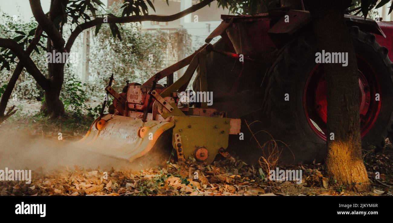 Nahaufnahme eines Traktors, der einen Hain auf einer Farm pflügt Stockfoto