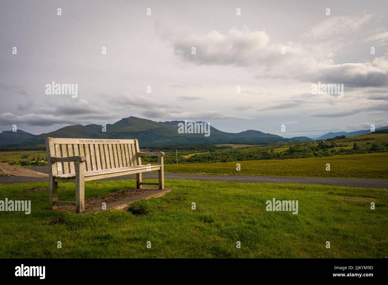 Eine Bank in den schottischen Highlands bei Sonnenuntergang, Spean Bridge Memorial und ein wolkig verhaufter Himmel Stockfoto