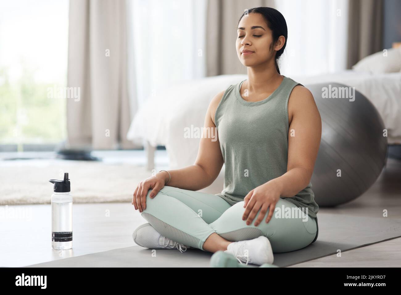 Ändern Sie Ihre Meinung, Einstellung und Stimmung. Eine sportliche junge Frau zu Hause meditieren. Stockfoto