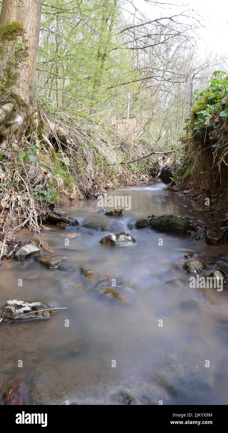 Sanftes und weiches Wasser in einem Bach durch Langzeitbelichtung, Stockfoto