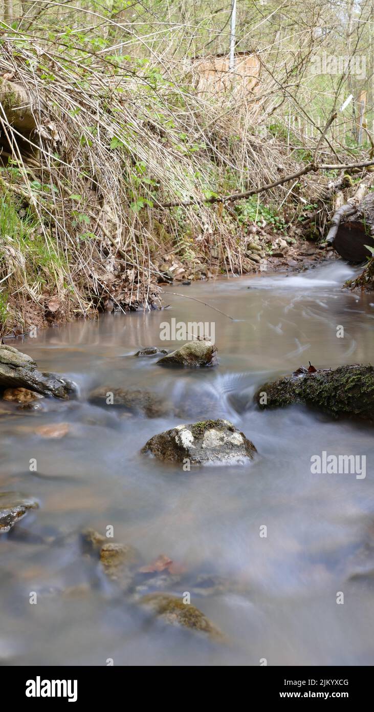 Sanftes und weiches Wasser in einem Bach durch Langzeitbelichtung, Stockfoto