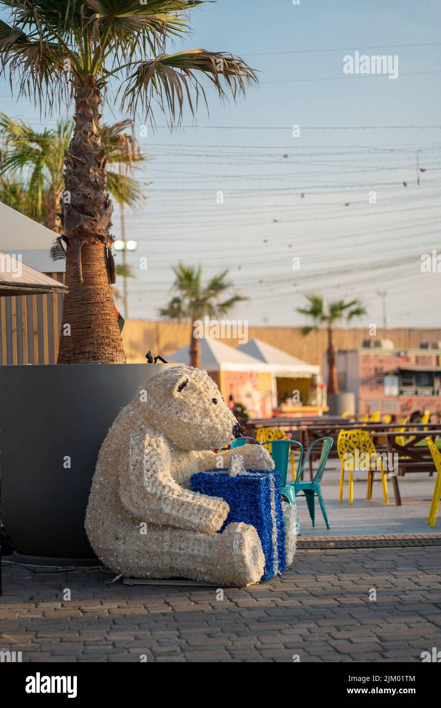 Eine vertikale Aufnahme eines Eisbären-Dummy während der Weihnachtszeit an einem sonnigen Tag in Dubai Festival City in Dubai, VAE Stockfoto