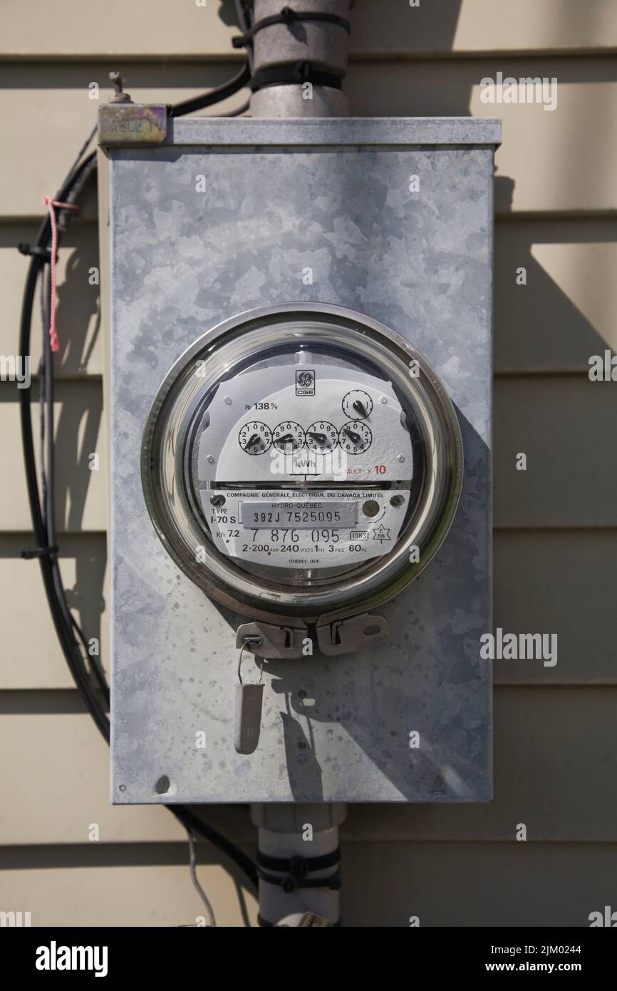 Strom-Messgerät für Wasserkraft an der Außenwand eines Hauses. Stockfoto