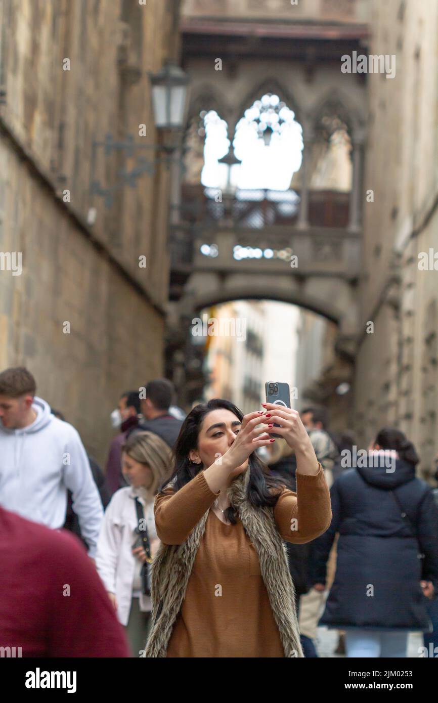 Barcelona, Katalonien, Spanien - 21. März 2022. Mädchen, die ein Selfie im Gotischen Viertel und der Seufzerbrücke in der Bisbe Straße in Barcelona (Spanien) machen. Stockfoto