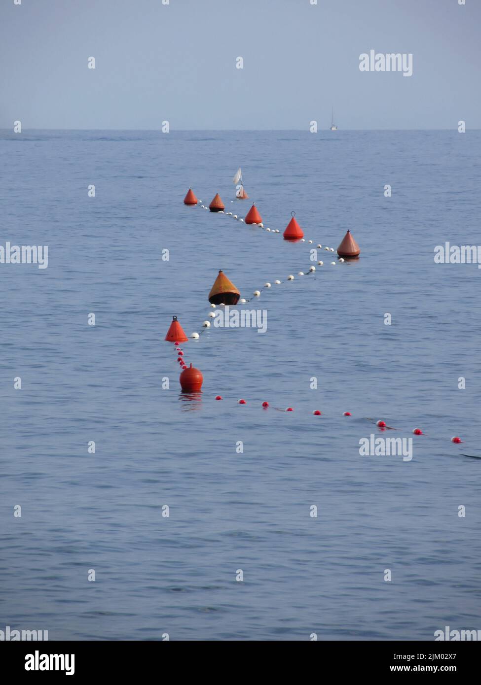 Viele Bojen auf dem Wasser schwimmend in der Marina. Kleines Boot an der Oberseite des Bildes sichtbar. Ruhiges Wasser mit kleinen Wellen Stockfoto