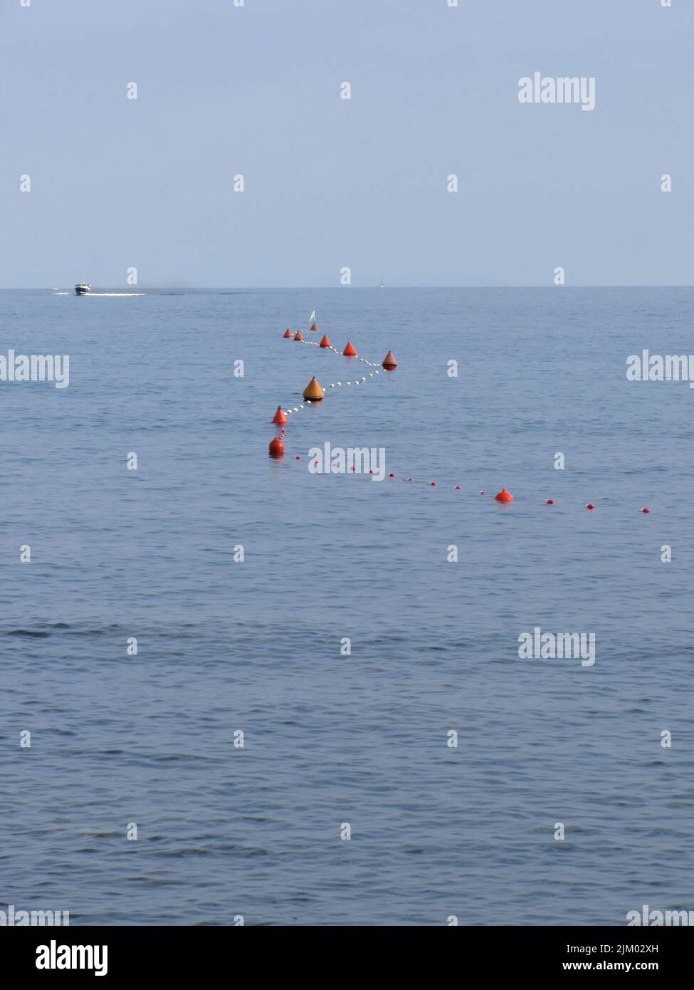 Viele Bojen auf dem Wasser schwimmend in der Marina. Kleines Boot an der Oberseite des Bildes sichtbar. Ruhiges Wasser mit kleinen Wellen Stockfoto