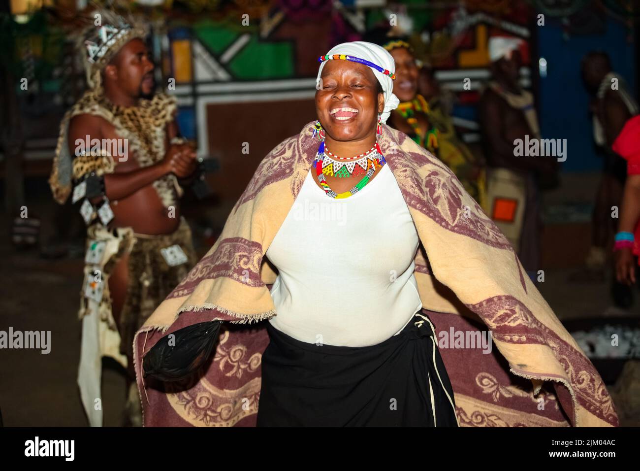 Eine afrikanische Frau, die einen Tanz in traditionellem Gewand aufführt Stockfoto