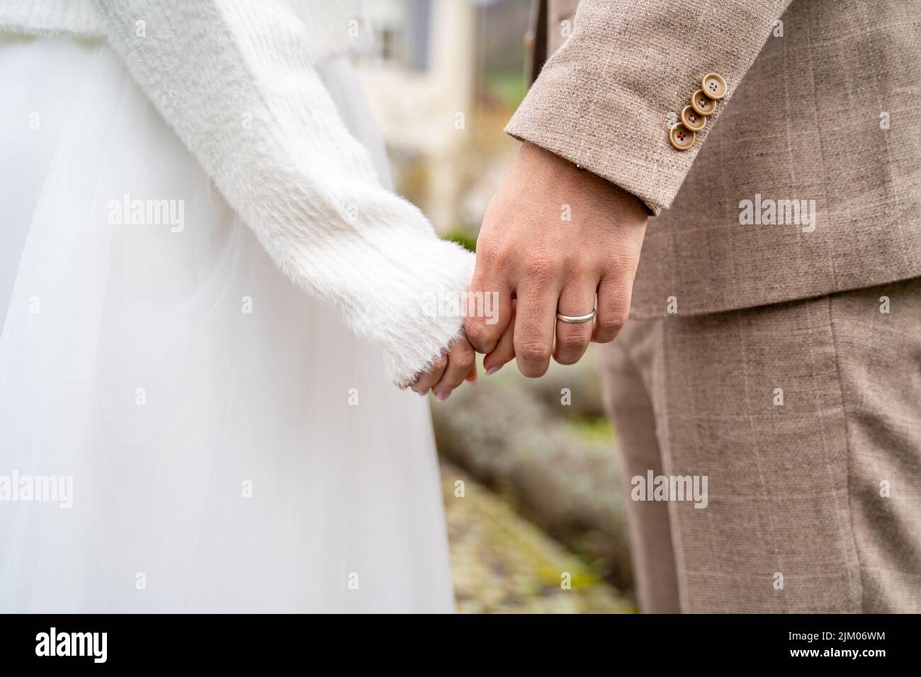 Eine Nahaufnahme eines Ehepaares, das während der Hochzeitszeremonie Hände mit Ringen hält Stockfoto