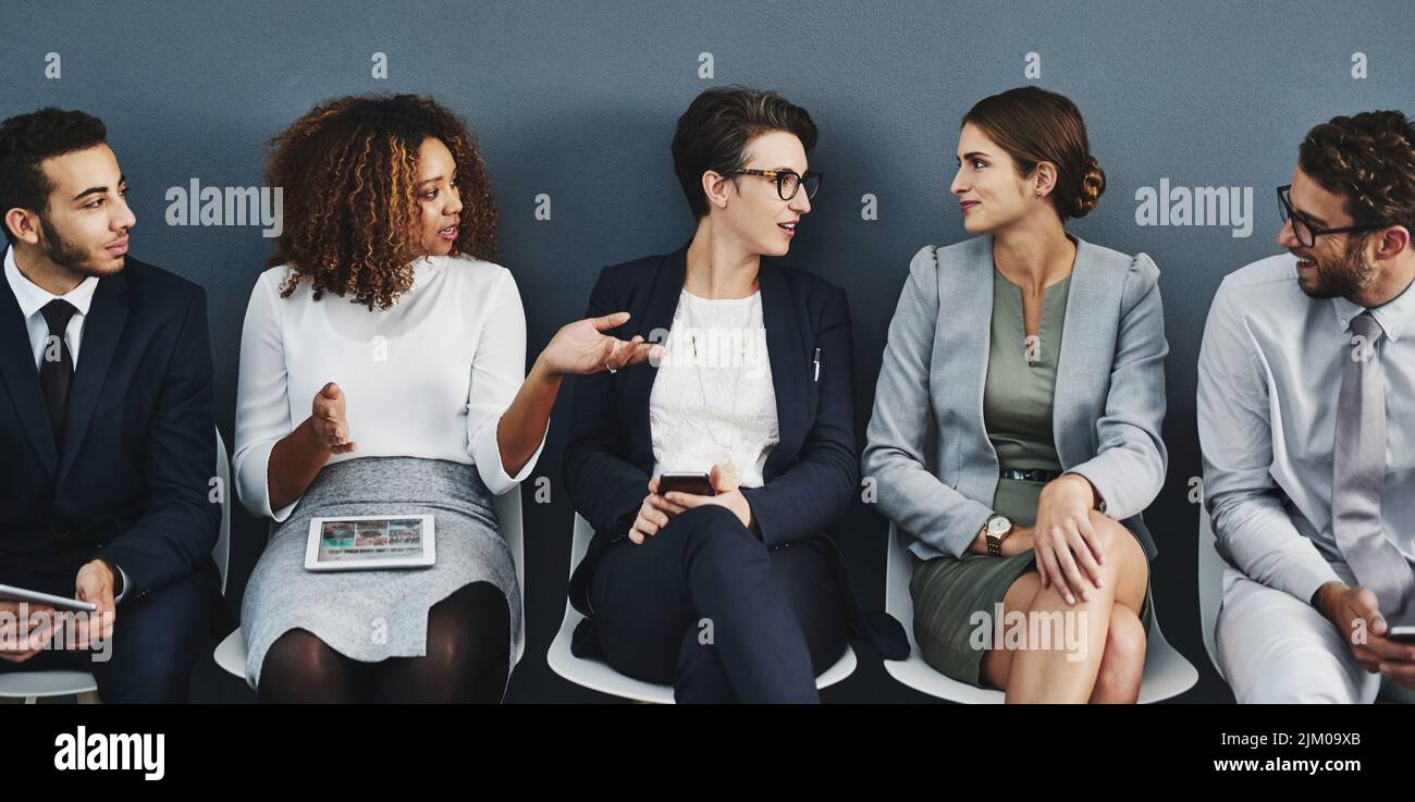 Geschäftsleute und das Team sprechen, während sie in der Schlange auf ein Interview, eine Besprechung oder ein Seminar warten. Diverse Unternehmensexperten und Kollegen Stockfoto