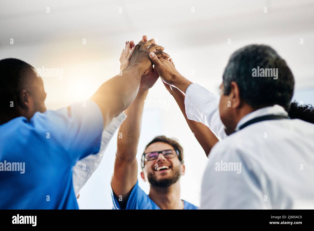 Glückliche Ärzte, medizinische Fachkräfte und Team geben hoch fünf in der Feier des Erfolgs, des Winings und der Leistung in einem Krankenhaus. Gesundheitsgruppe Stockfoto