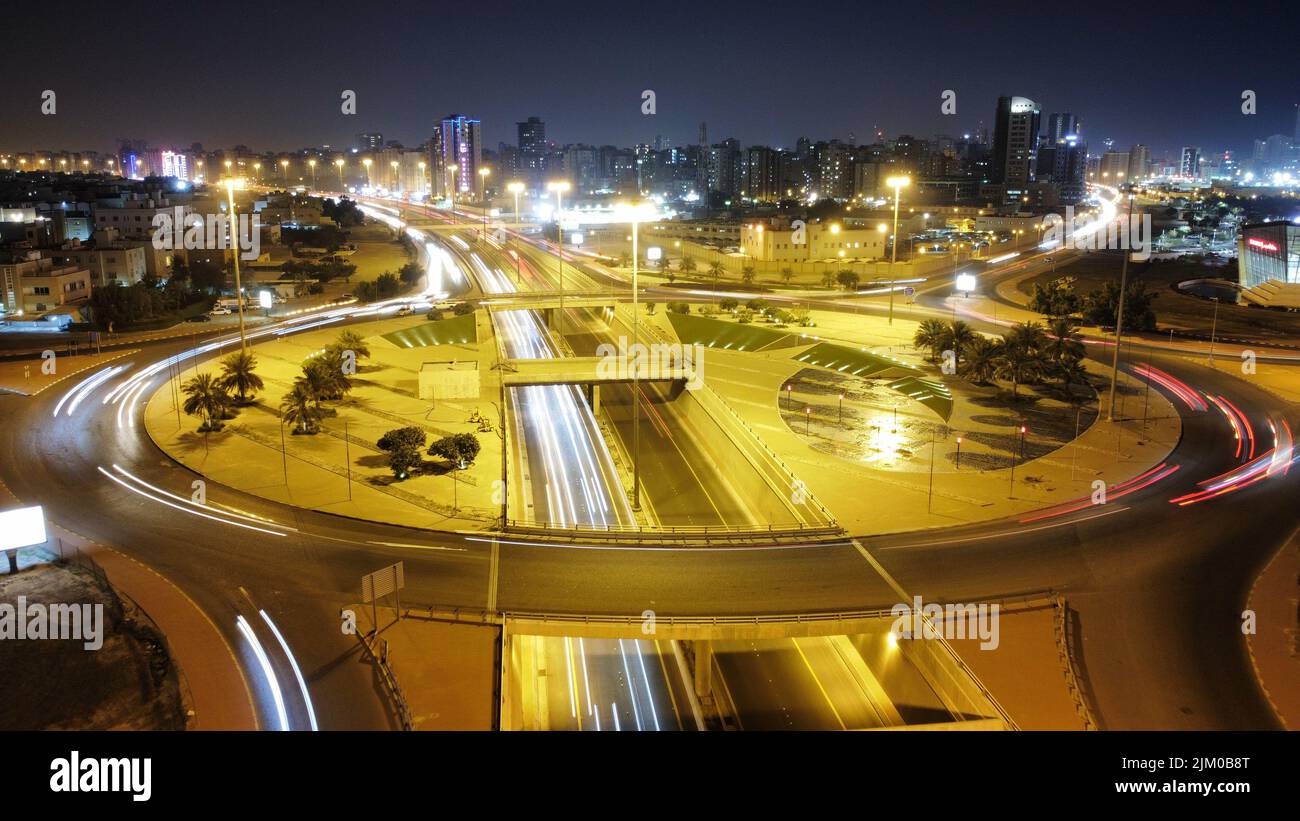 Eine Langzeitaufnahme der Kuwait Towers und des Platzes bei Nacht mit den Lichtern der Stadt Stockfoto