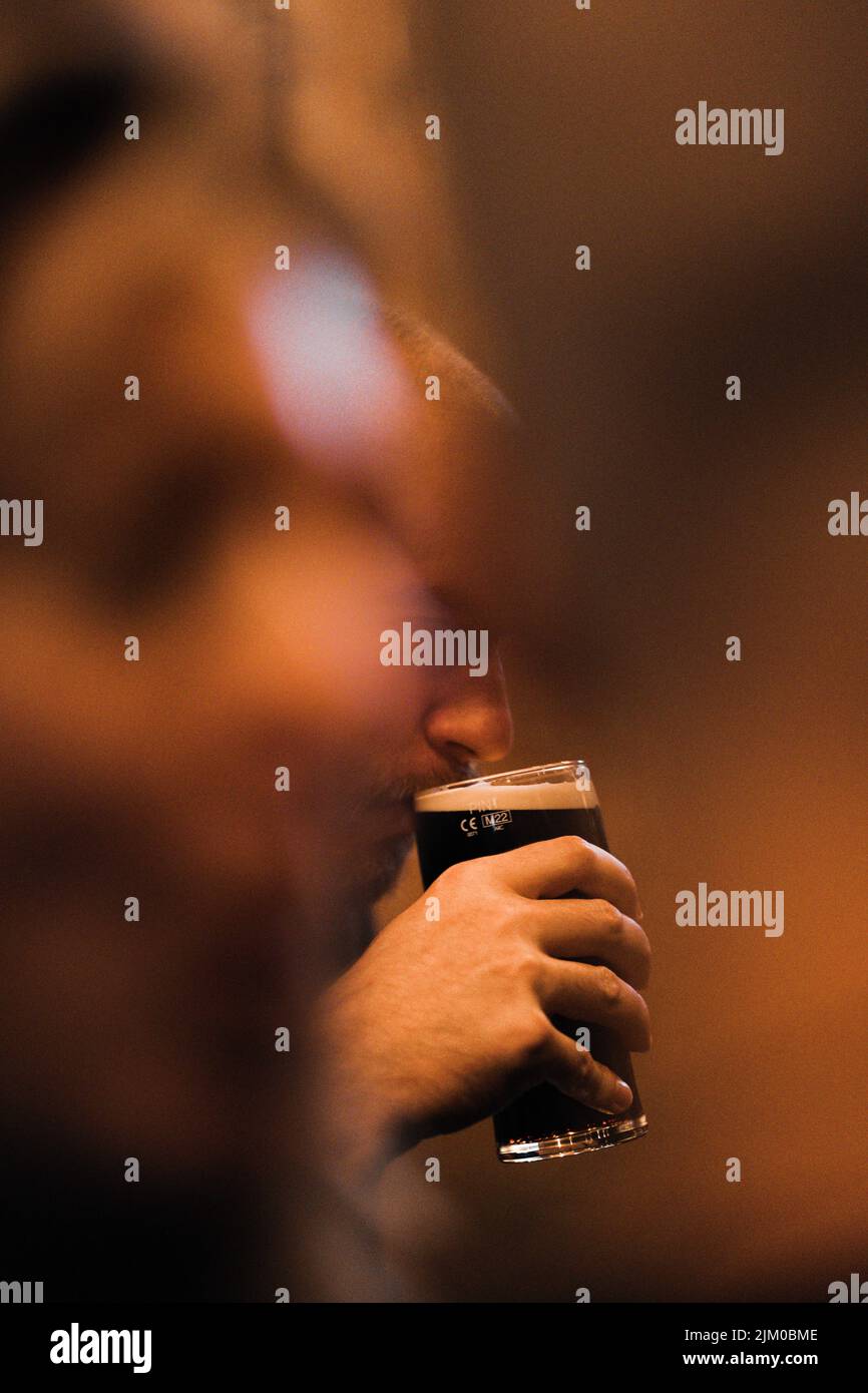 Eine Nahaufnahme einer Hand, die ein Glas Bier hält Stockfoto