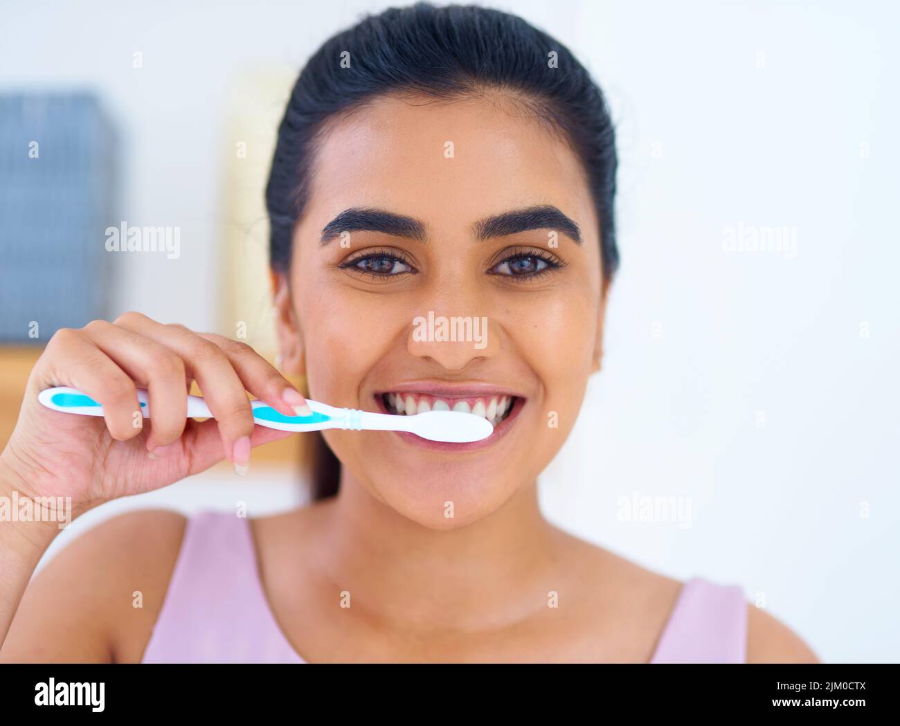 Ihr strahlendes Lächeln in einem tadellosem Zustand zu halten. Porträt einer jungen Frau, die sich zu Hause die Zähne putzt. Stockfoto