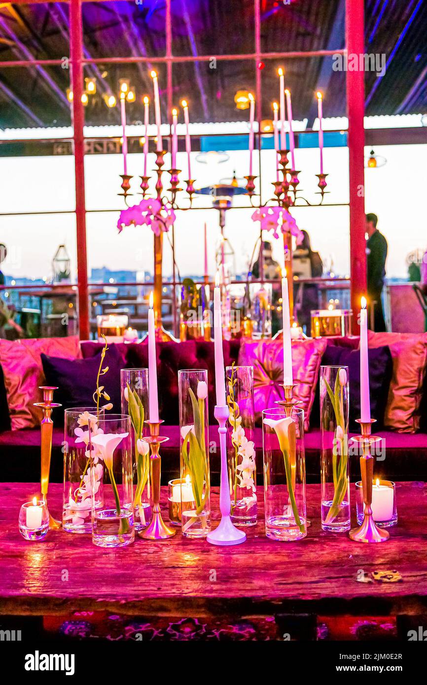 Ein Restauranttisch mit dekorativen Kerzenständern und Blumen Stockfoto