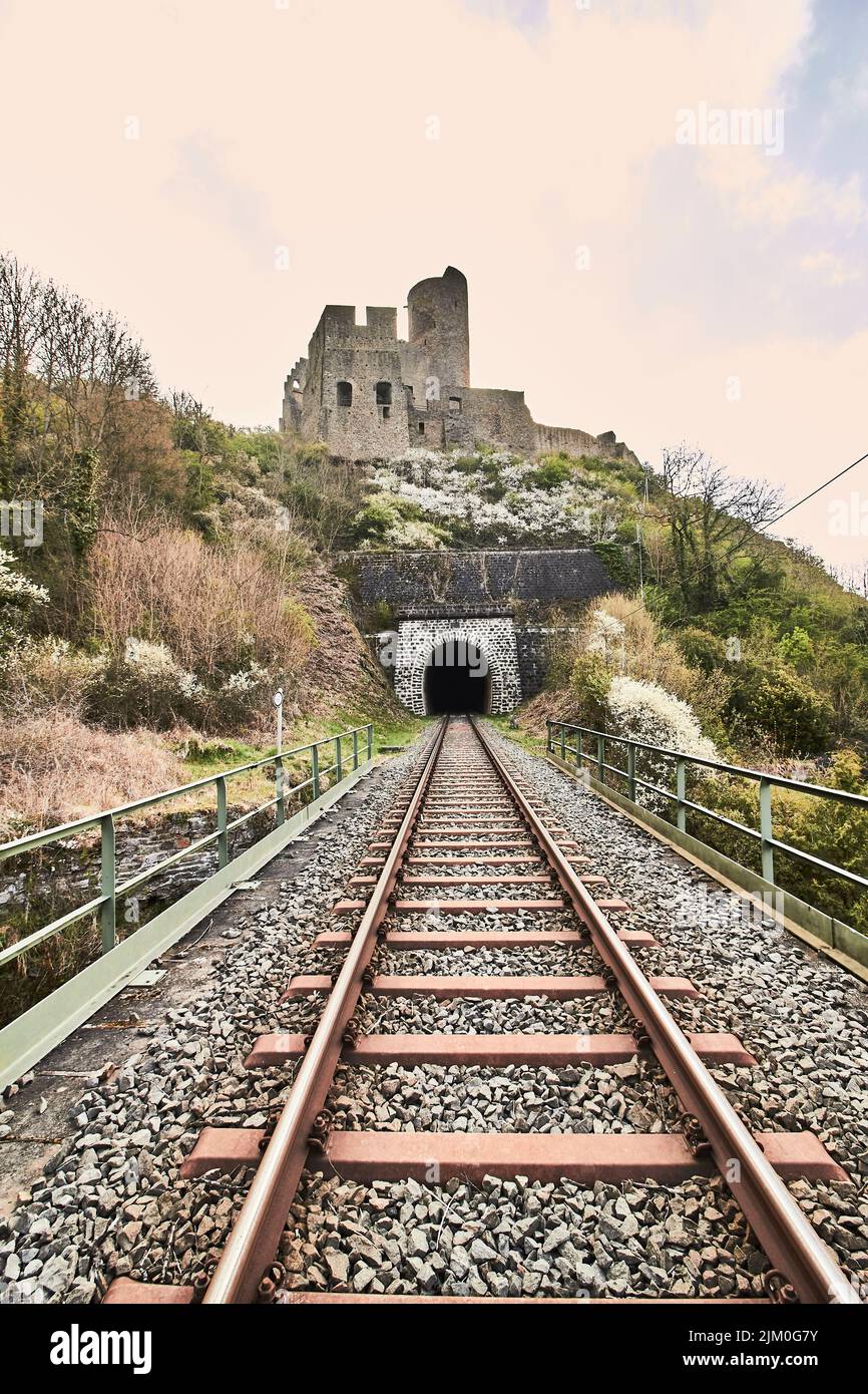 Der Zug fährt mit der Lowenburg im Hintergrund in Monreal Stockfoto