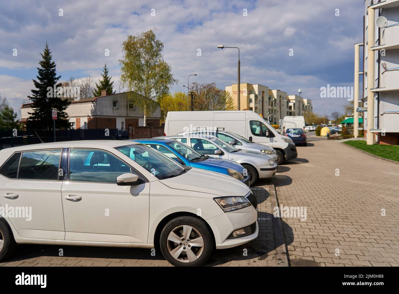 Eine Reihe geparkter Autos auf Parkplätzen vor einem Mehrfamilienhaus in Posen, Polen Stockfoto