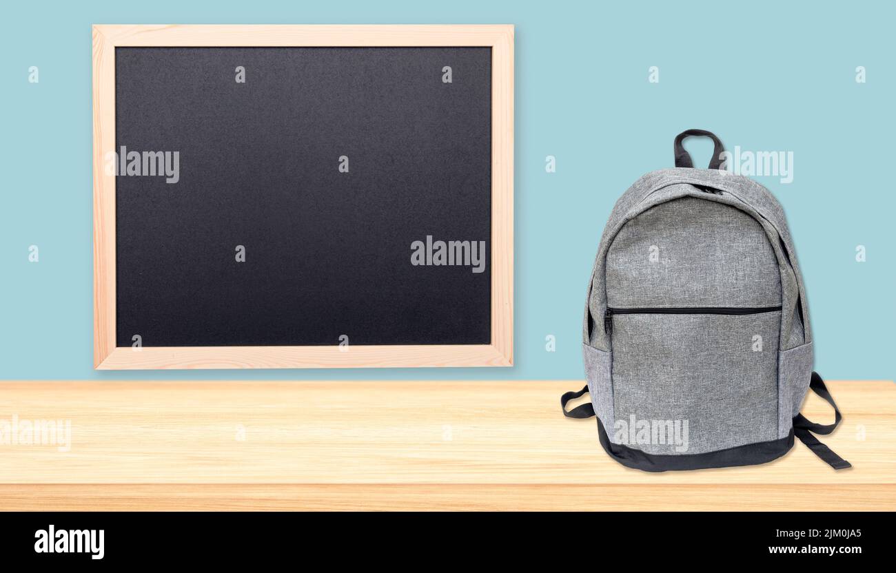 Minimale Zusammensetzung von Tafel, Tischplatte mit freiem Platz und Rucksack, Konzeptbild über Bildung Stockfoto