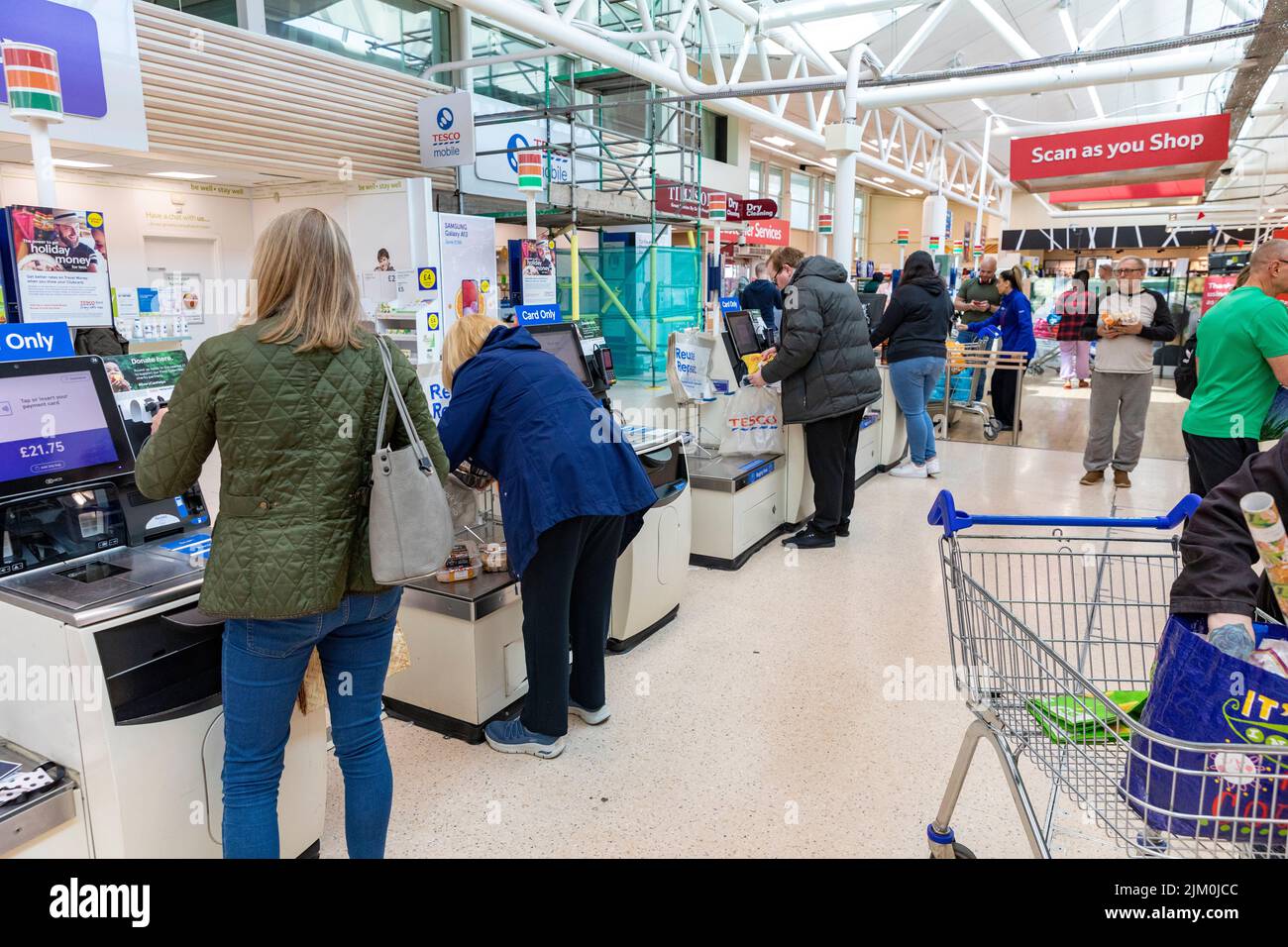 Tesco Supermarkt, Kunden mit Selbstbedienungsautomaten, um für ihre Lebensmittel zu bezahlen, Tesco bietet auch Scan-as-you-Shop-Service, Manchester, Großbritannien Stockfoto