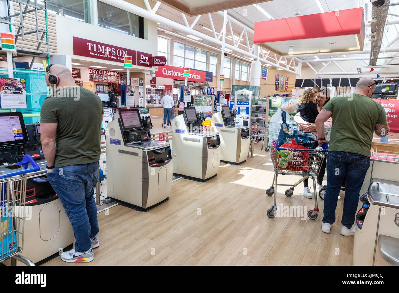 Tesco Supermarkt, Kunden mit Selbstbedienungsautomaten, um für ihre Lebensmittel zu bezahlen, Tesco bietet auch Scan-as-you-Shop-Service, Manchester, Großbritannien Stockfoto