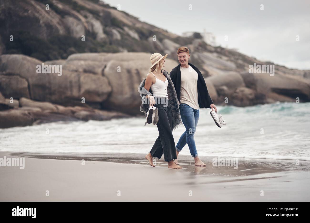 Wir konnten stundenlang nur am Strand spazieren gehen, ein Paar hielt sich die Hände beim Strandspaziergang. Stockfoto