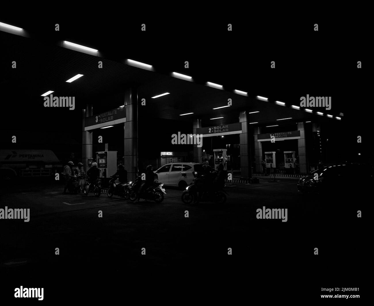 Eine Graustufenaufnahme einer Tankstelle in der Nacht Stockfoto