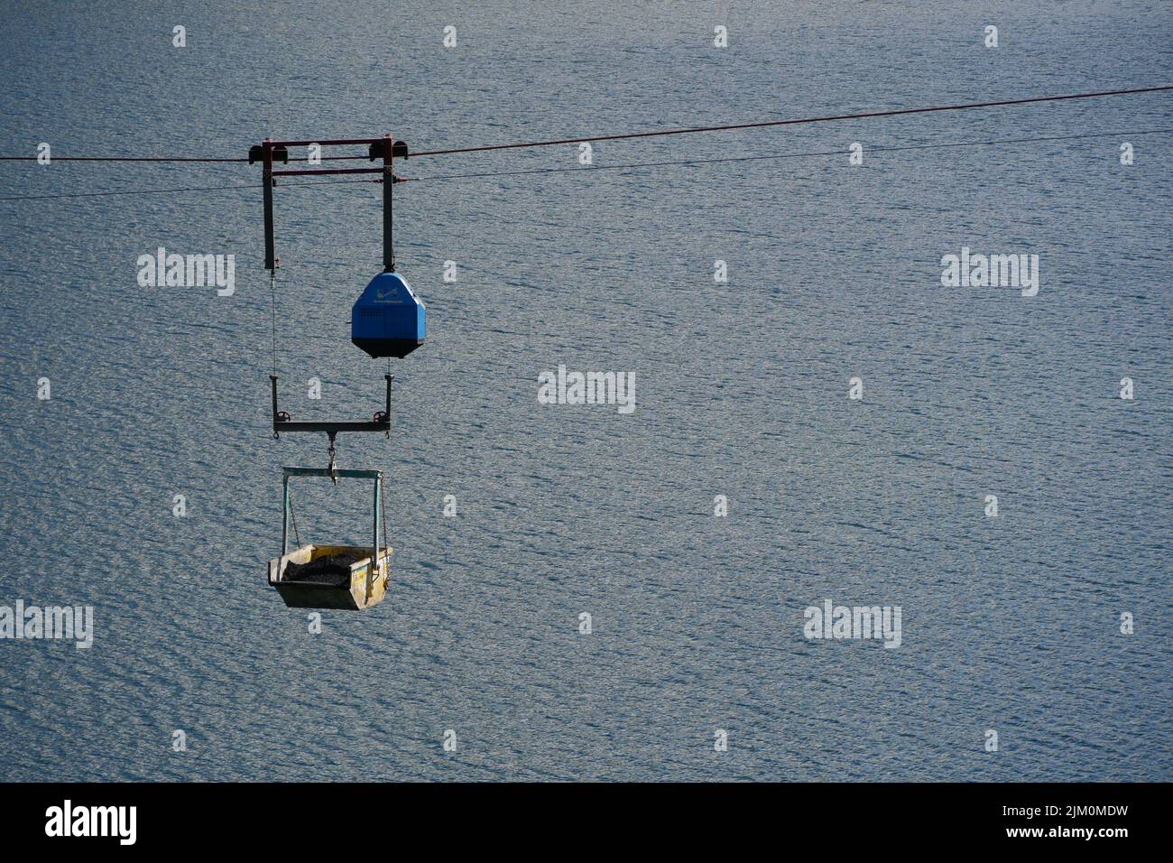 Seilbahnwagen, die hoch über einem See fliegen Stockfoto