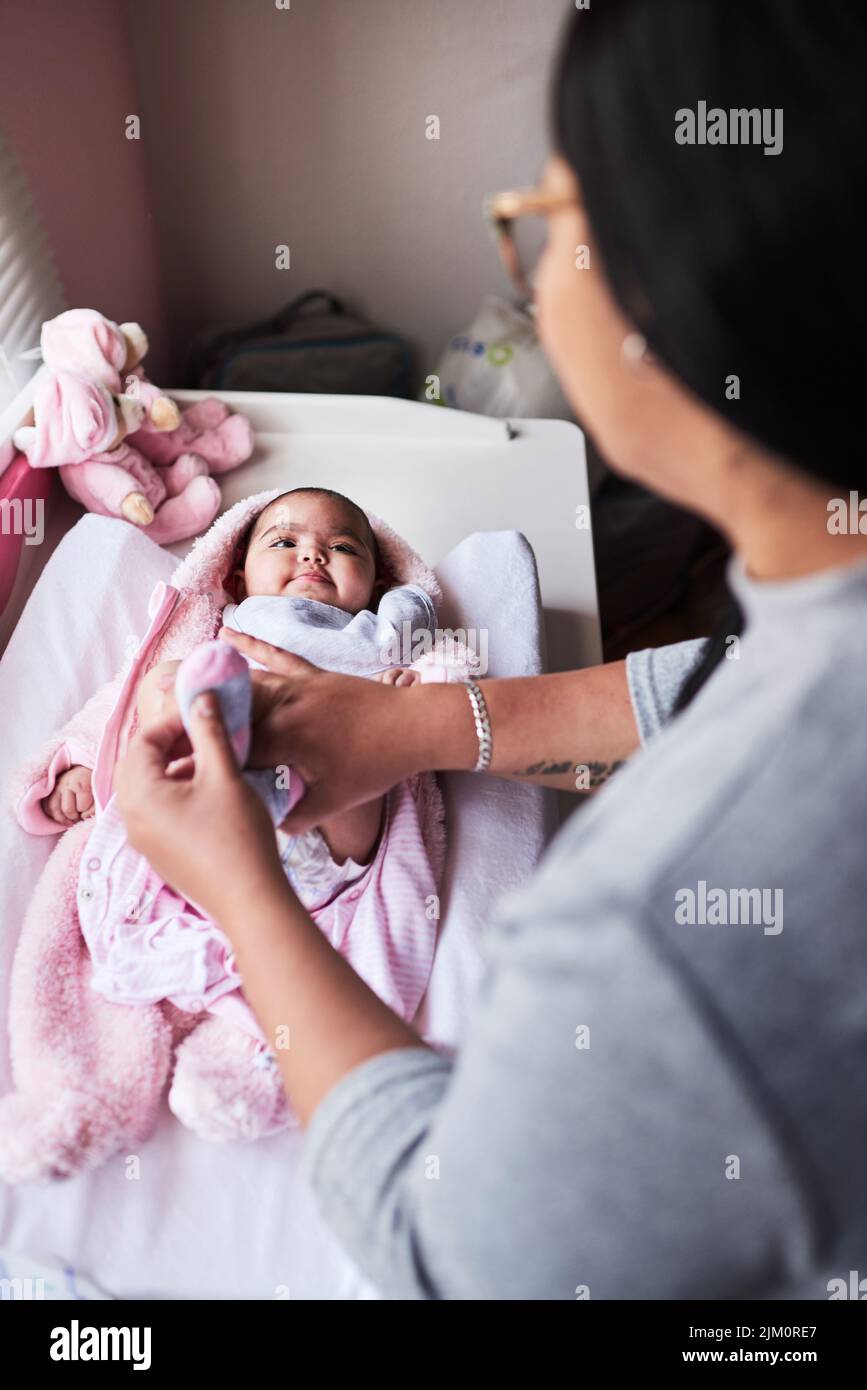 Das Leben wurde gerade viel süßerer. Eine Frau, die zu Hause ihre Babykleidung wechselt. Stockfoto