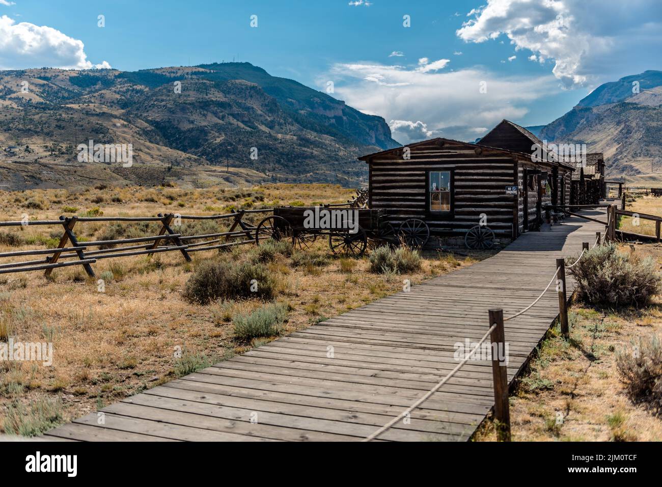 Ein altes Westernhaus auf einem Feld mit Bergen im Hintergrund in Cody, Wyoming Stockfoto