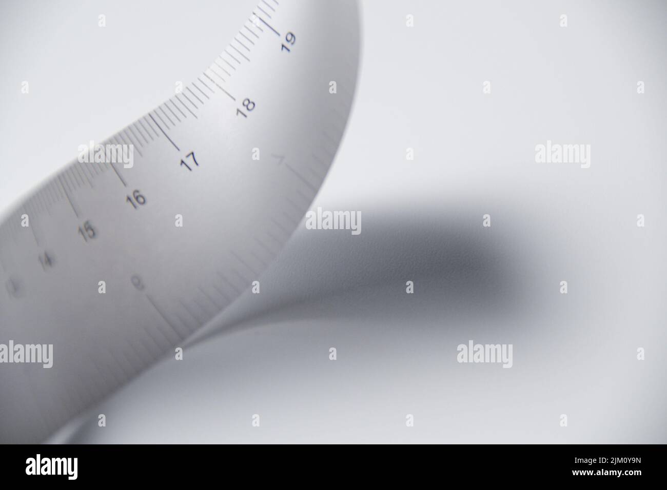 Ein graues Maßband auf weißem Hintergrund Stockfoto