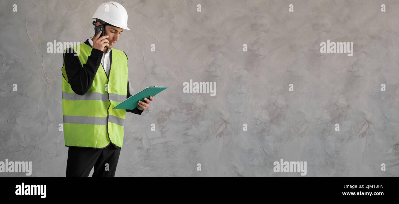 Builder-Manager. Ein Ingenieur spricht am Telefon. Baupläne vom Architekten. Mann in Baueruniform isoliert auf Hintergrund. Architekt Stockfoto