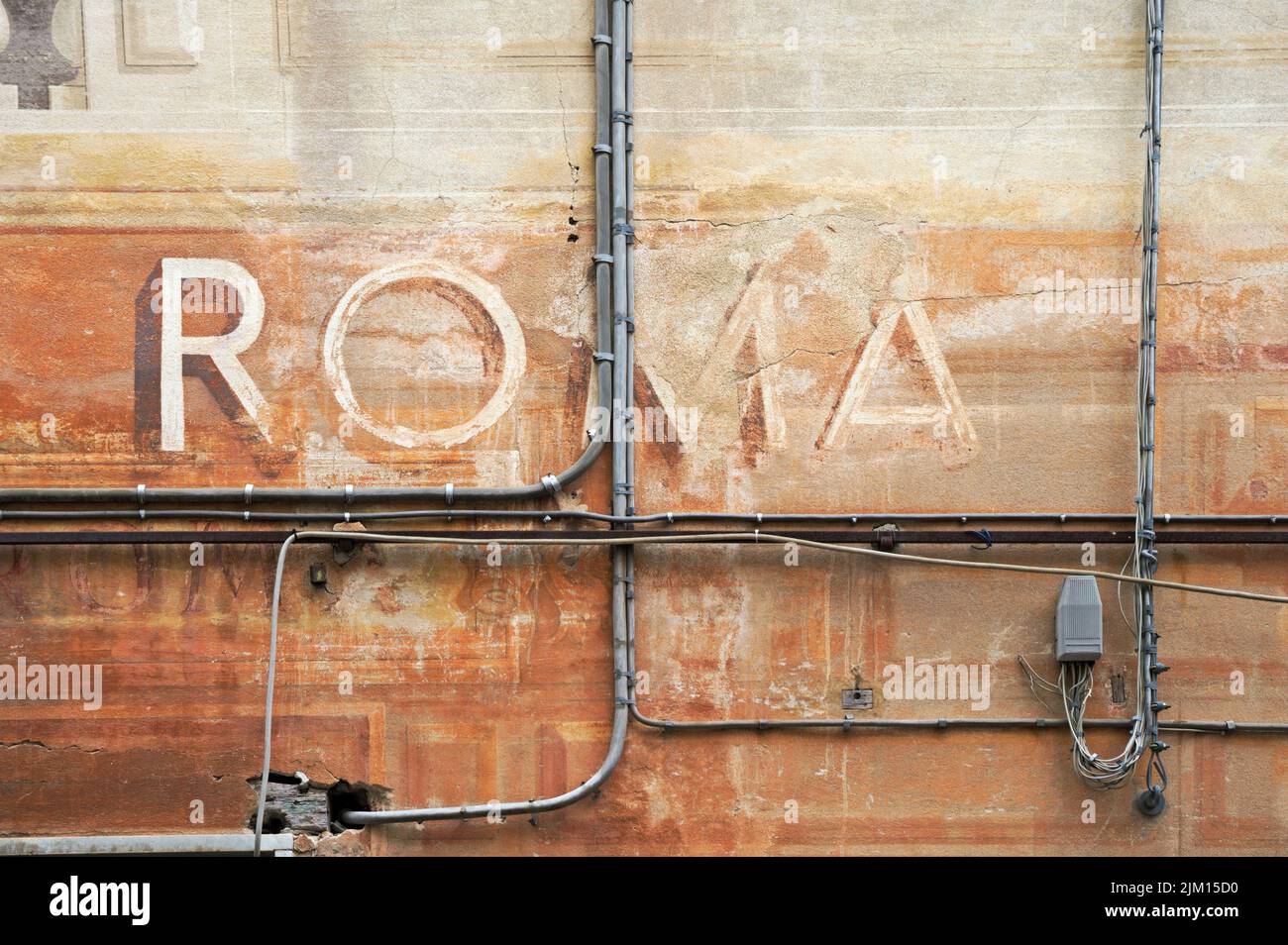 Fading lackiertes Schild ROMA an der Wand mit Kabeln Stockfoto